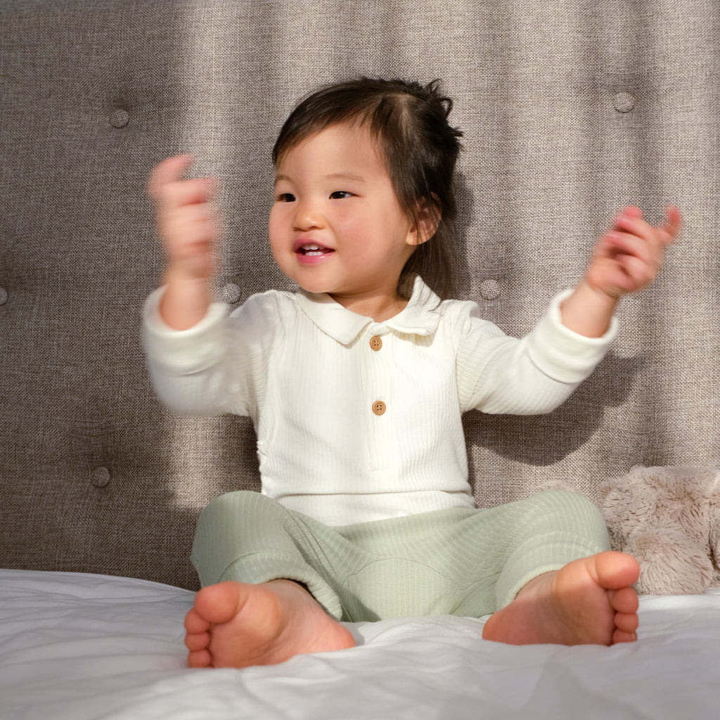 Our model wearing BAO Baby Wear buttons bodysuit in vanilla and lounge pants in matcha.