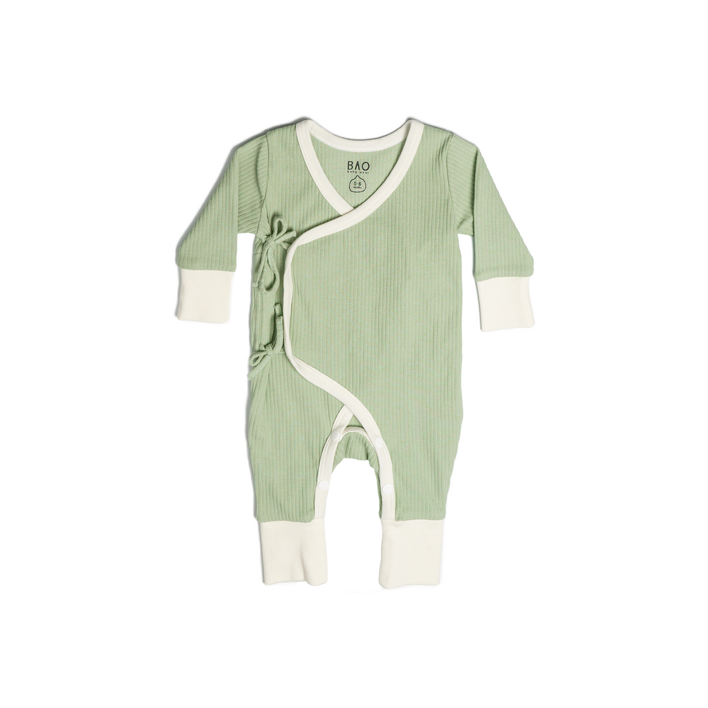 A set of kimono opening pyjamas in a mossy green (matcha). Made from ribbed cotton. Shown in its large setting.  Edit alt text