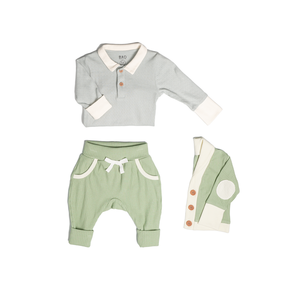 The toddler essentials bundle, consisting of a collared bodysuit in a gentle blue (butterfly pea) pointelle patterned cotton, paired with lounge pants in matcha and ribbed cotton and a cardigan in matcha ribbed cotton.