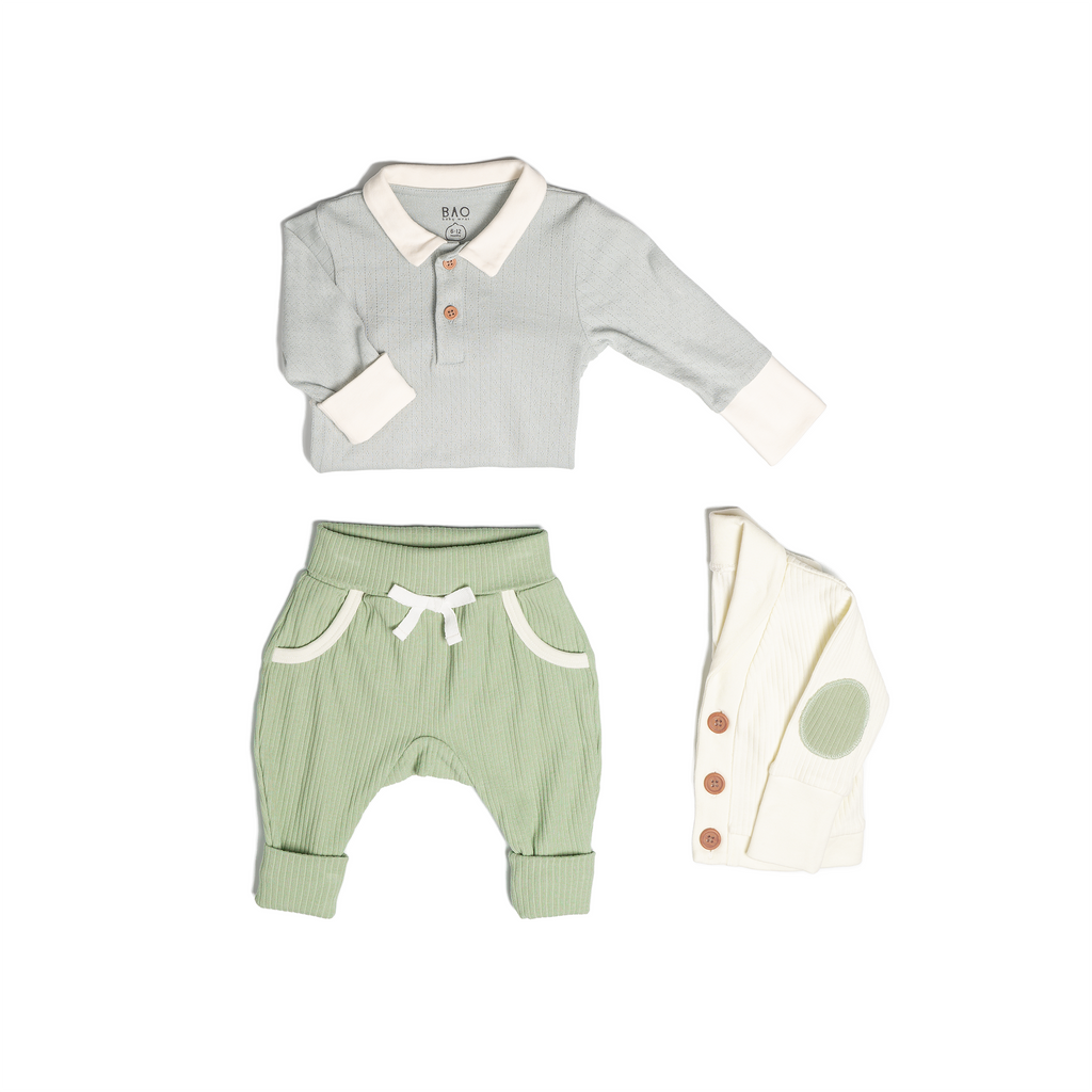 The toddler essentials bundle, consisting of a collared bodysuit in a gentle blue (butterfly pea) pointelle patterned cotton, paired with lounge pants in matcha and ribbed cotton and a cardigan in vanilla ribbed cotton.
