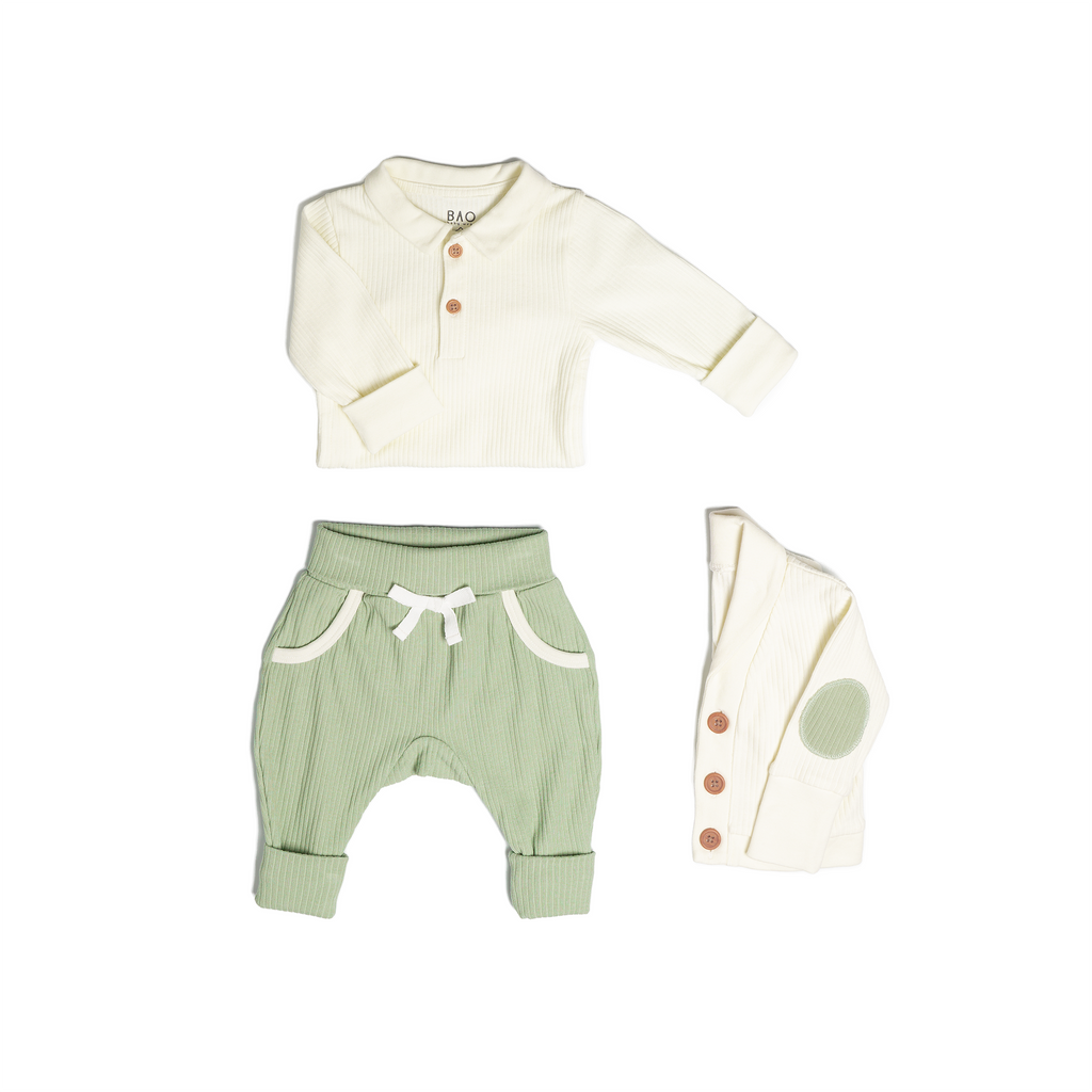 The toddler essentials bundle, consisting of a collared bodysuit in vanilla ribbed cotton, paired with lounge pants in matcha and ribbed cotton and a cardigan in vanilla ribbed cotton.