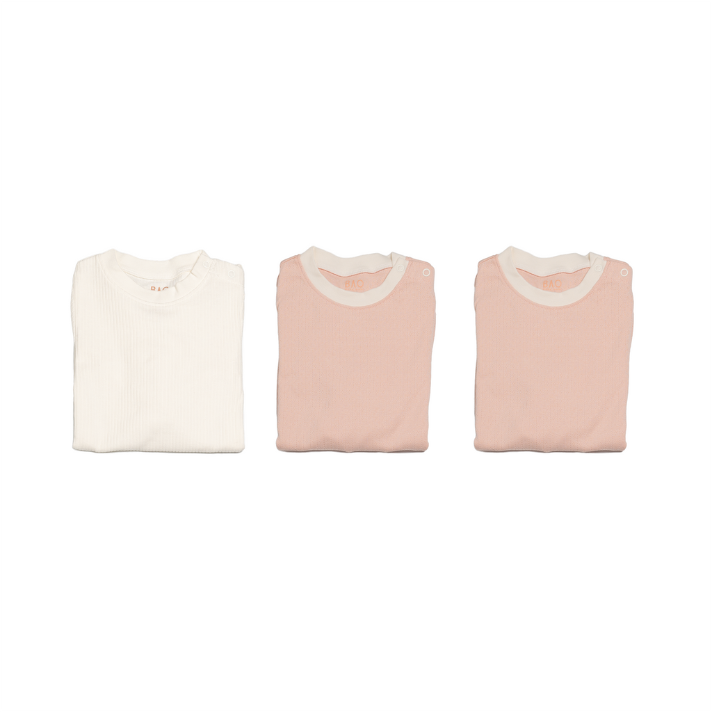 The newborn sleepy time bundle, consisting of 3 sets of pyjamas. One in ribbed cotton vanilla, two in pointelle cotton peach.